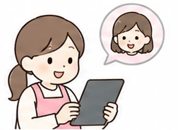 タブレットで記録を書く職員と、それを見る保護者