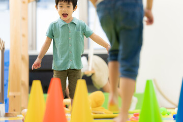 コーンの間を歩く子どもと見守る職員