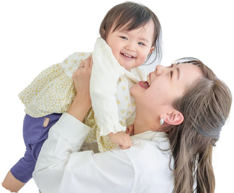 笑顔で子どもを高く抱き上げるお母さん